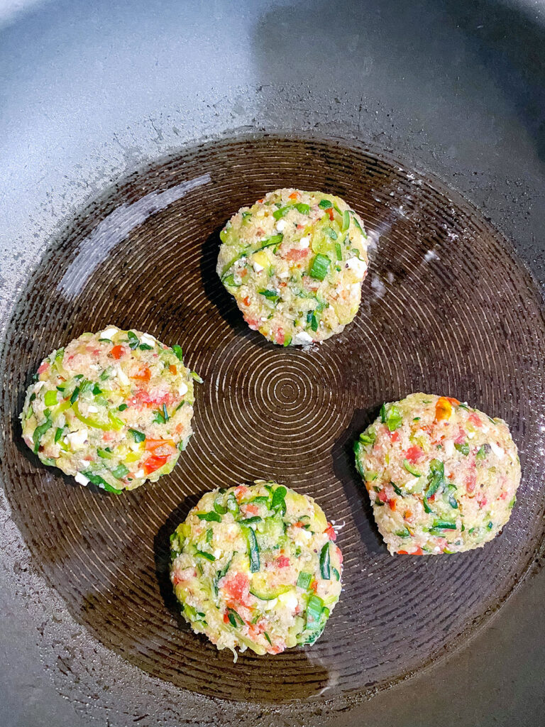 Greek zucchini cakes cooking in olive oil in skillet
