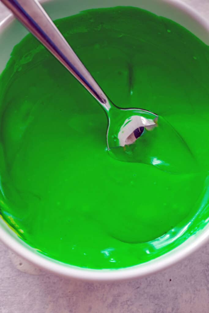 Overhead view of bright green Irish whiskey frosting in a bowl