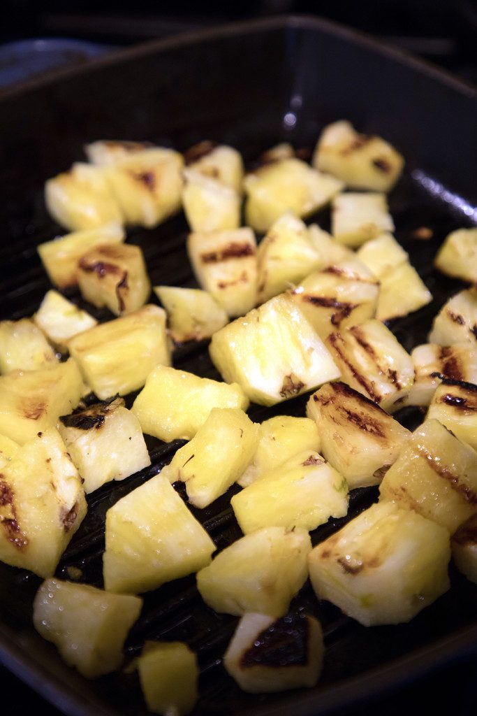 Overhead view of chopped pineapple with grill marks n grill pan 