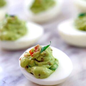 Guacamole Deviled Eggs -- Not only are Guacamole Deviled Eggs much tastier than the average deviled egg, but they're healthier, too! Using minimal egg yolks, these party appetizers are packed with heart healthy avocado instead | wearenotmartha.com