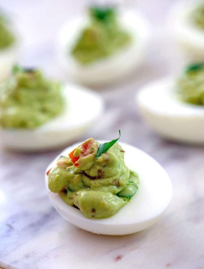 Guacamole Deviled Eggs -- Not only are Guacamole Deviled Eggs much tastier than the average deviled egg, but they're healthier, too! Using minimal egg yolks, these party appetizers are packed with heart healthy avocado instead | wearenotmartha.com