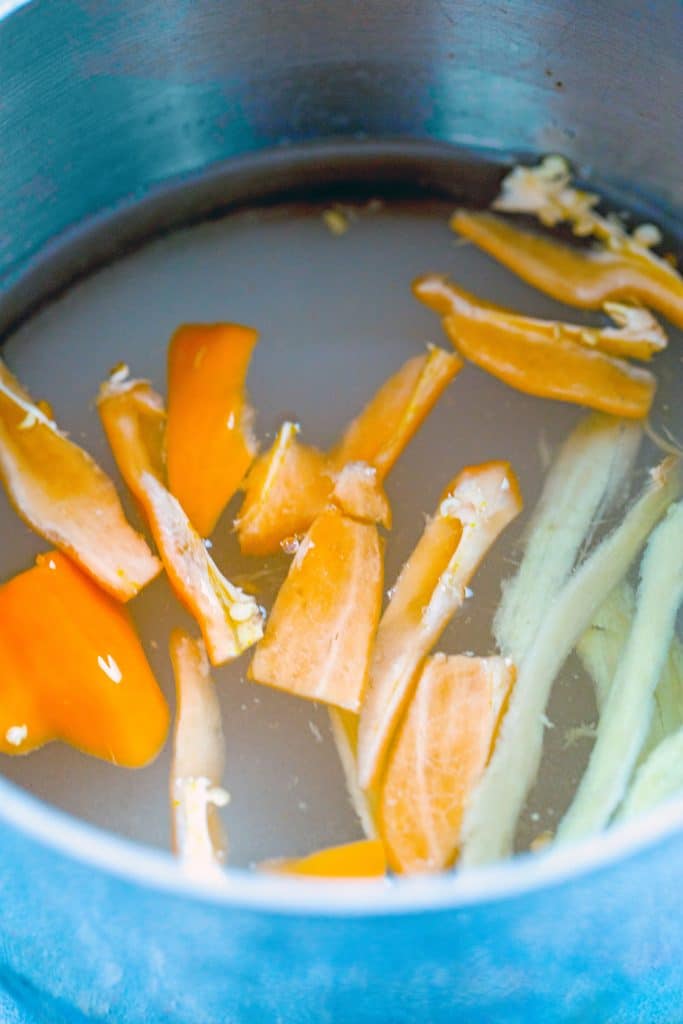 Overhead view of sliced habanero peppers in saucepan with sugar and water for simple syrup