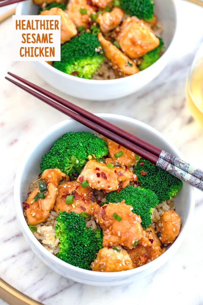 Overhead view of a white bowl of sesame chicken and broccoli over rice in a white bowl with chopsticks on a marble surface with a second bowl in the background and recipe title at top.