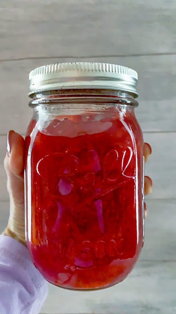 Head-on view of mason jar filled with strawberry jam