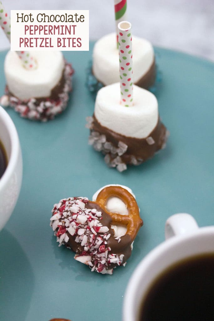 Overhead view of a hot chocolate peppermint pretzel bite surrounded by chocolate-dipped marshmallows and mugs of coffee with recipe title at top