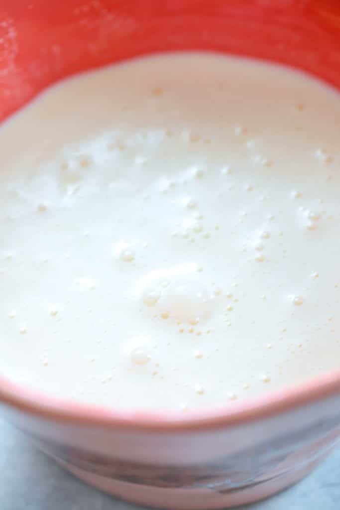 Overhead view of peach bowl filled with cream and milk mixture for ice cream