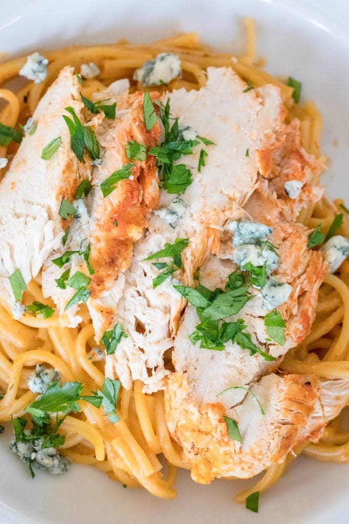 Overhead close-up view of buffalo chicken over pasta with parsley and blue cheese made in Instant Pot