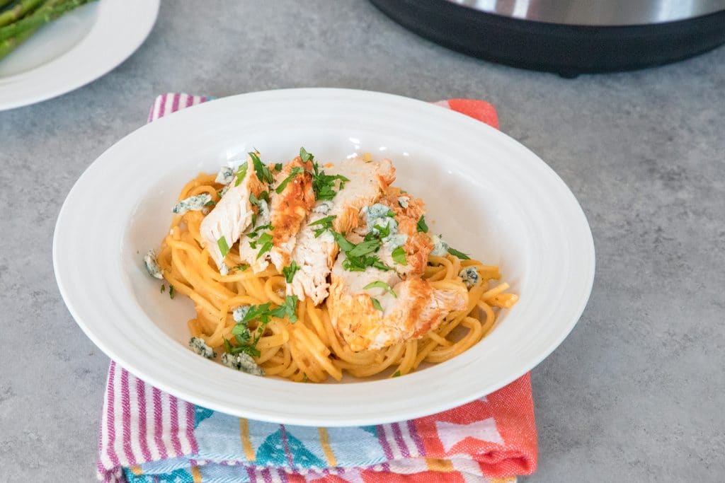 Landscape head-on view of white bowl filled with buffalo chicken pasta made in Instant Pot