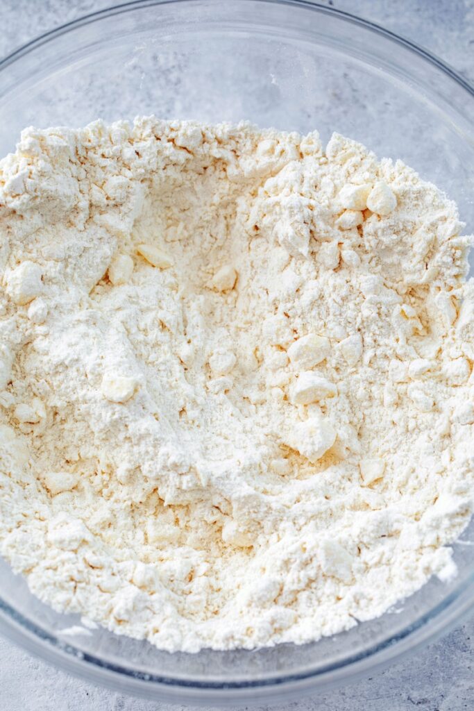 Overhead view of flour mixture with butter cut in