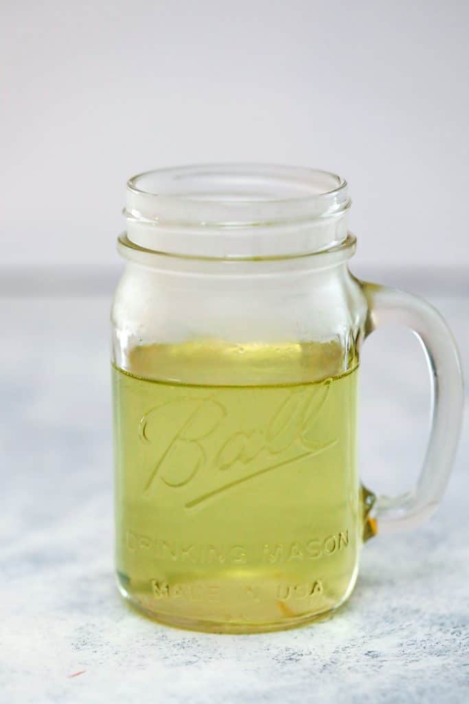 Head-on view of mason jar filled with jalapeño simple syrup