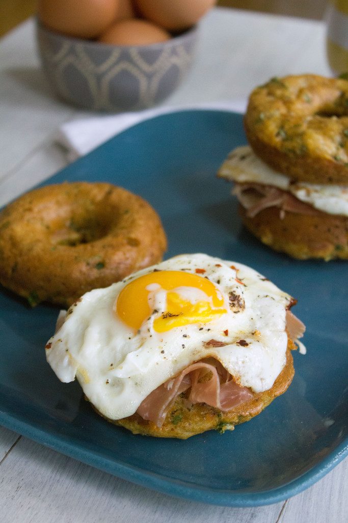 Kale Cheddar Doughnut Egg Sandwiches -- Eggs and prosciutto sandwiched between two savory doughnuts | wearenotmartha.com 