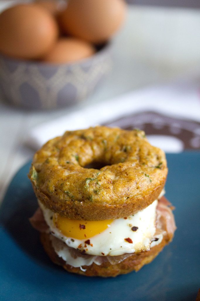 Kale Cheddar Doughnut Egg Sandwiches -- Eggs and prosciutto sandwiched between two savory doughnuts | wearenotmartha.com 