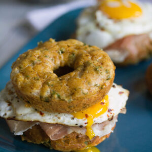 Kale Cheddar Doughnut Egg Sandwiches -- Eggs and prosciutto sandwiched between two savory doughnuts | wearenotmartha.com