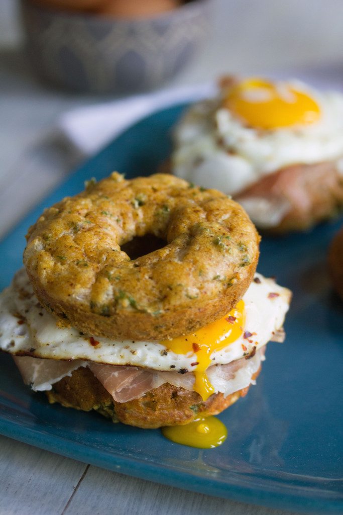 Kale Cheddar Doughnut Egg Sandwiches -- Eggs and prosciutto sandwiched between two savory doughnuts | wearenotmartha.com 