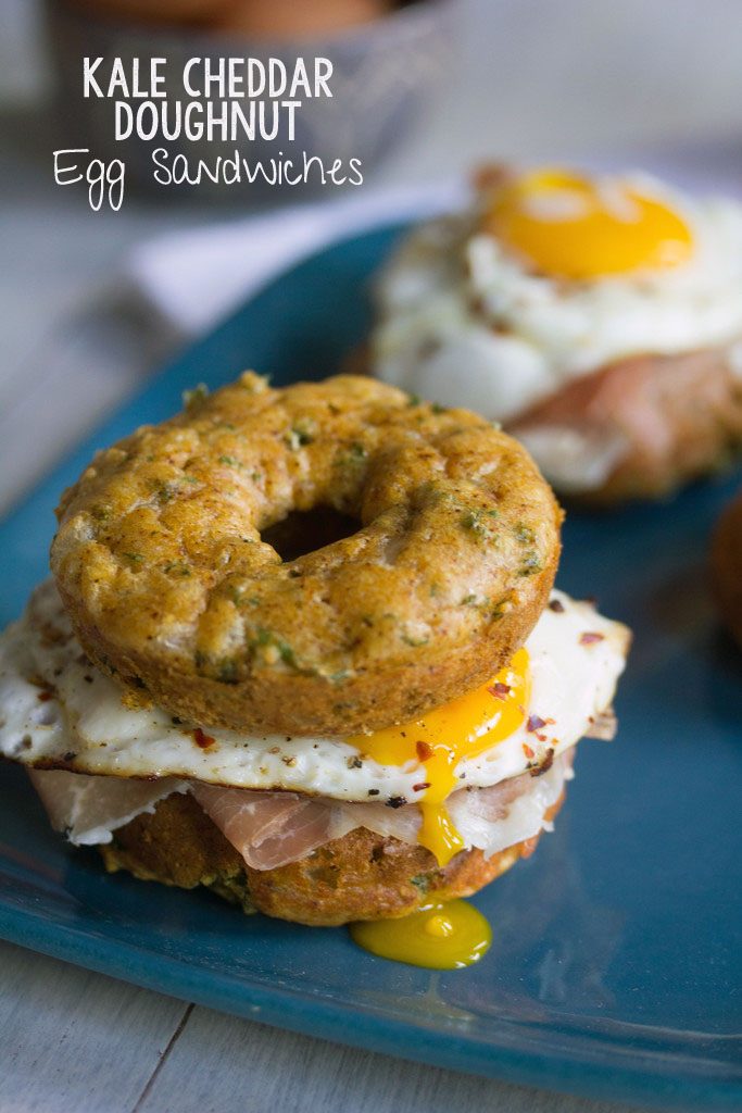 Kale Cheddar Doughnut Egg Sandwiches -- Eggs and prosciutto sandwiched between two savory doughnuts | wearenotmartha.com 