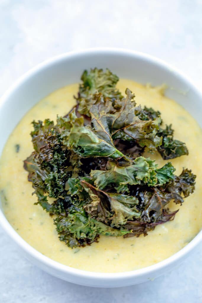Crispy kale on top of polenta in bowl