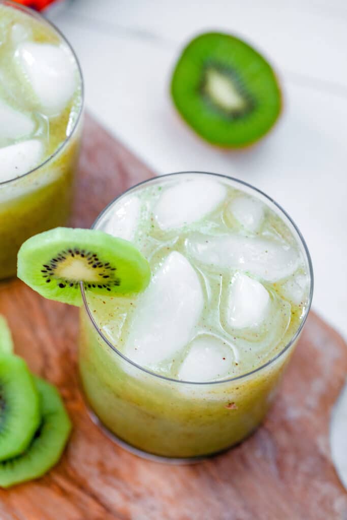 Overhead view of a kiwi mint tequila cocktail with kiwi garnish