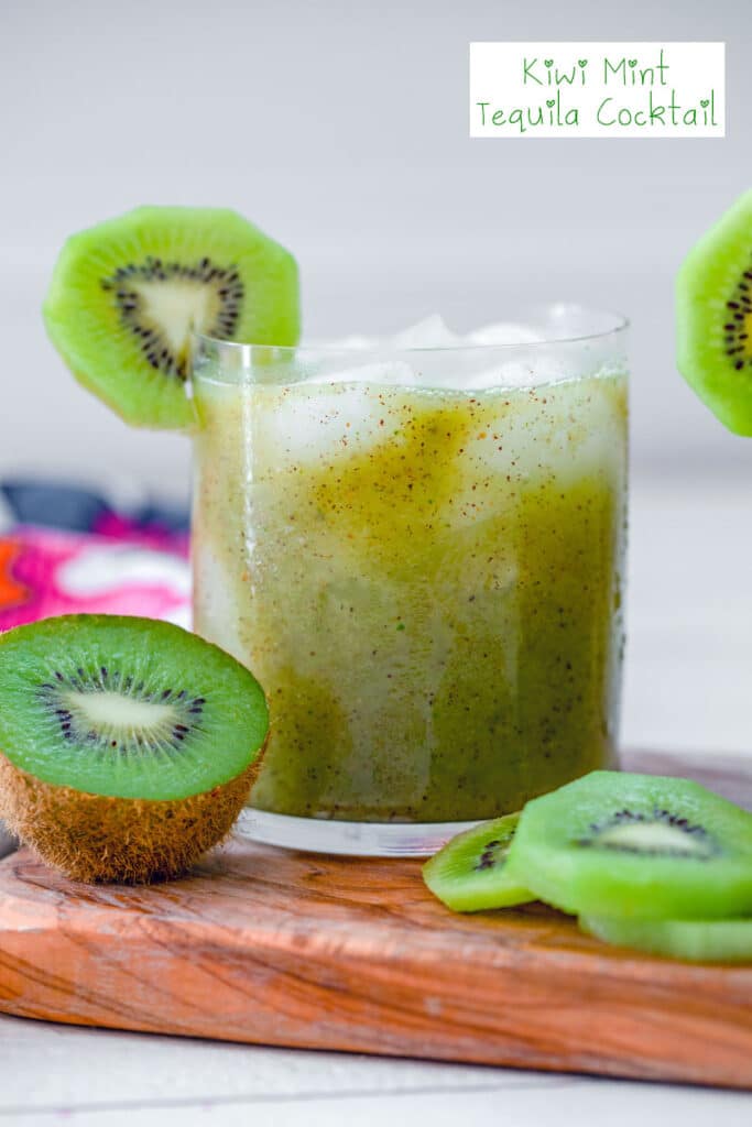 Head-on view of a kiwi mint tequila cocktail with kiwi fruit all around and recipe title at top