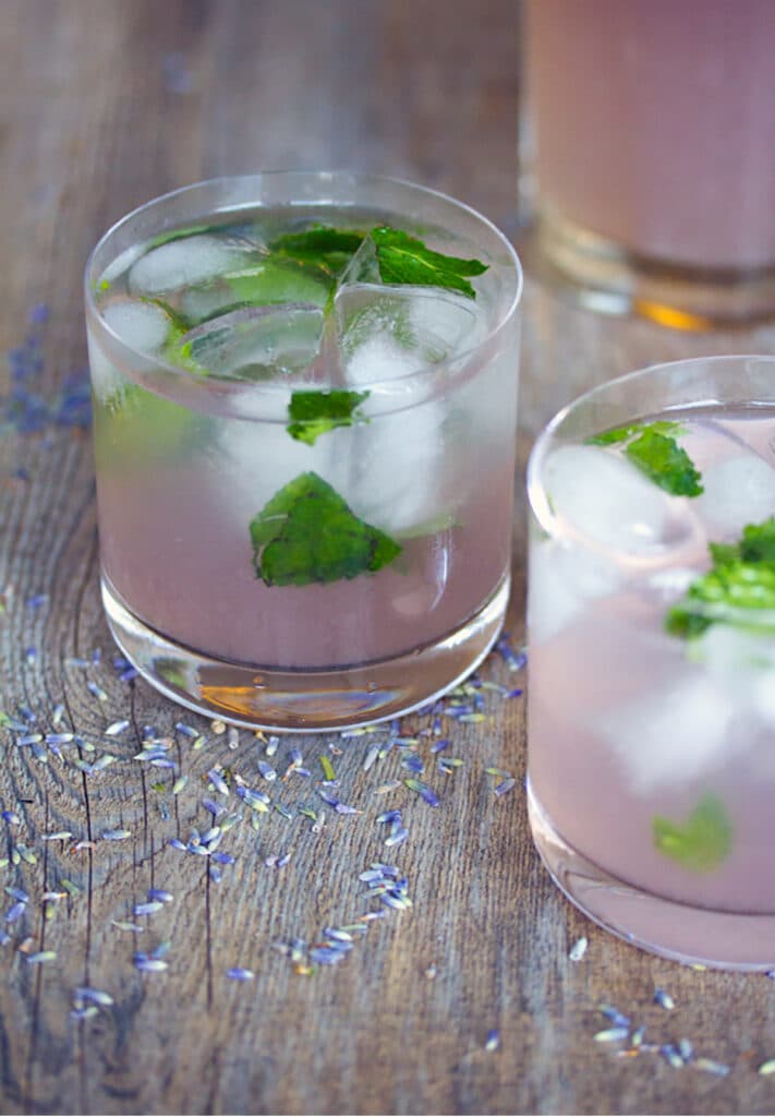 Head-on view of lavender lemonade mojito on a wood surface with dried lavender