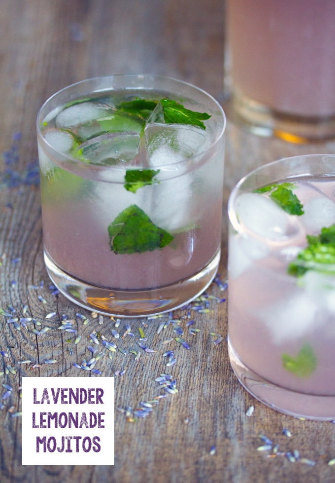 Head-on visning af lavendel lemonade mojito på en træoverflade med tørret lavendel og "lavendel Lemonade Mojitos" tekst på bunden af foto"Lavender Lemonade Mojitos" text on the bottom of photo