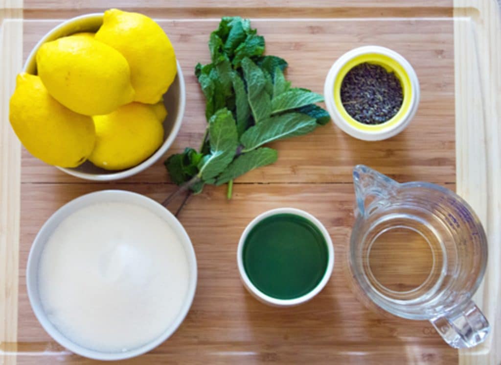 alle ingrediensene som trengs for lavendel lemonade mojitos satt ut: sitroner, mynte, sukker, vann, rom og tørket lavendel