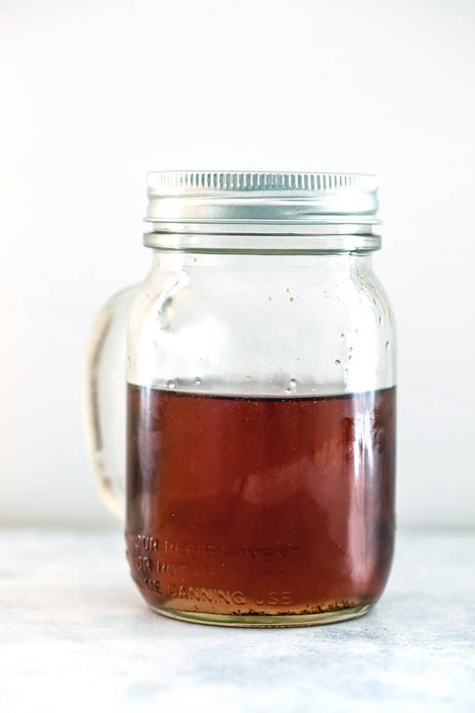 Head-on view of a mason jar filled with lavender simple syrup