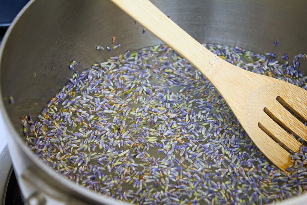 Dried lavender in a pot with water and sugar in the process of becoming lavender simple syrup.