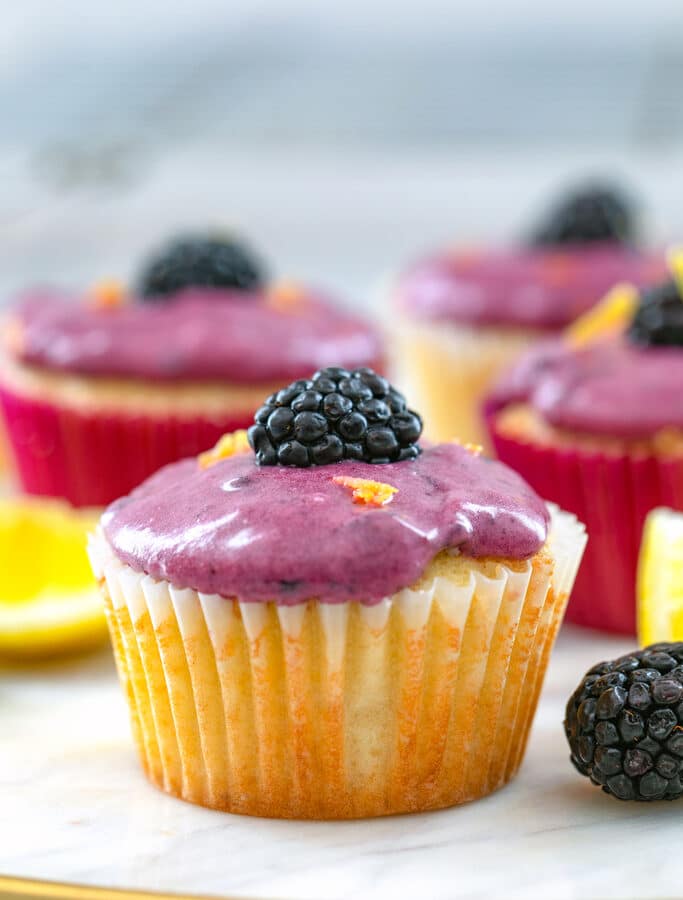 Lemon Cupcakes with Blackberry Cream Cheese Frosting -- Welcome spring with these Lemon Blackberry Cupcakes... The lemon cupcakes have a lemon curd filling and a deliciously pretty blackberry cream cheese frosting! | wearenotmartha.com