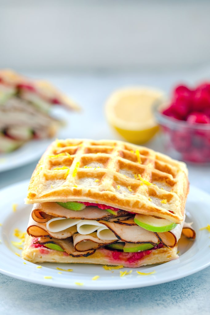 These Lemon Waffle Sandwiches are loaded with honey turkey, provolone cheese, and green apples, with a simple raspberry spread. They're perfect for enjoying during a late summer's picnic or any time of year!