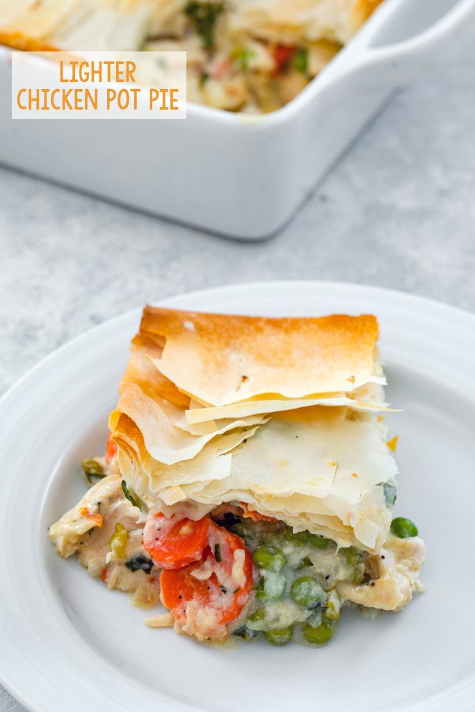 Overhead view of a serving of lighter chicken pot pie with peas and carrots on a white plate with the baking dish in the background and recipe title at top