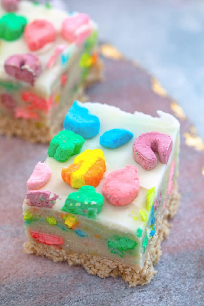 Closeup overhead view of a Lucky Charms cookie dough bar with buttercream frosting top with marshmallows