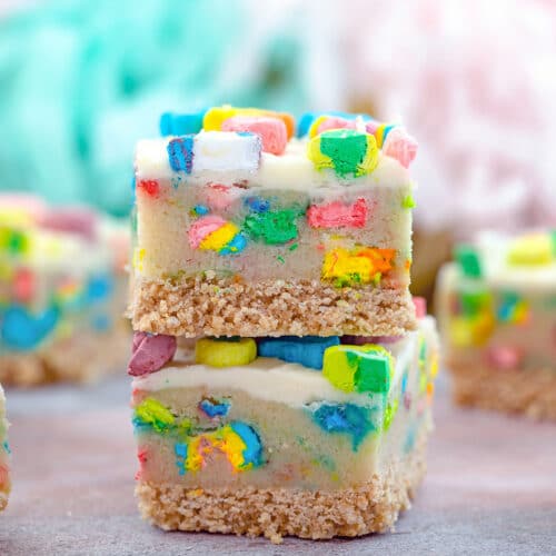 Head-on view of two Lucky Charms cookie dough bars stacked on each other with more bars in the background