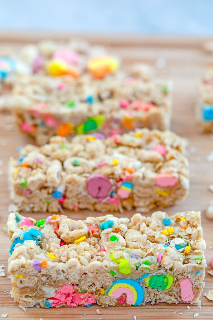 Overhead view of Lucky Charms granola bars lined up on a cutting board.
