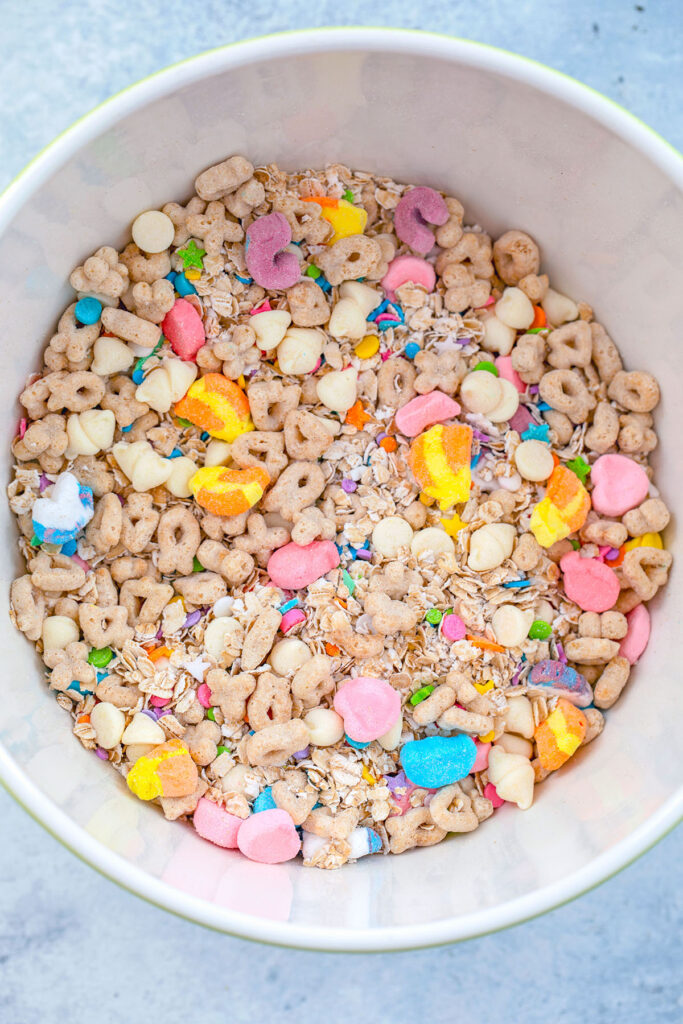 Overhead view of a bowl filled with Lucky Charms cereal mixed with quick cooking oats, white chocolate chips, and sprinkles.