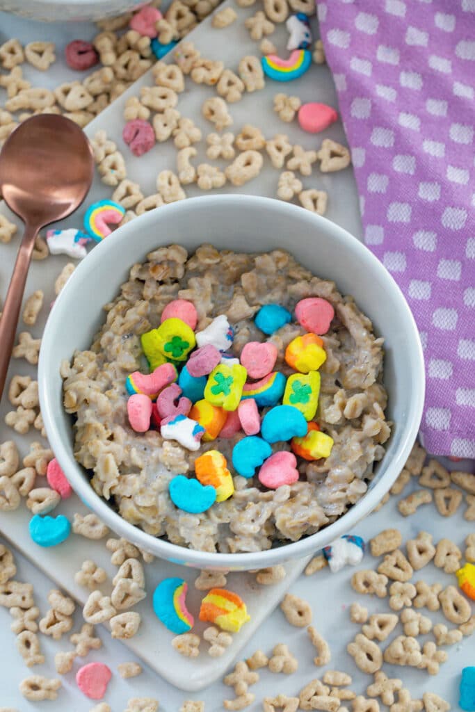 Overhead view of Lucky Charms oatmeal in bowl with marshmallows on top and cereal all around.