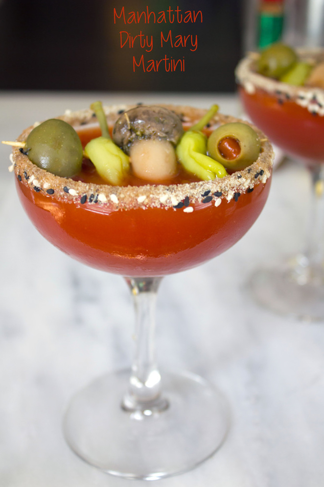 Head-on closeup view of a dirty bloody mary martini with salted rim and garnish with recipe title at top