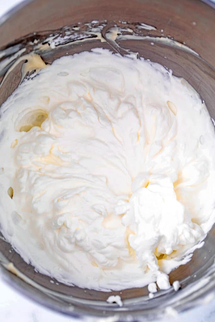 Whipped cream with stiff peaks in mixing bowl