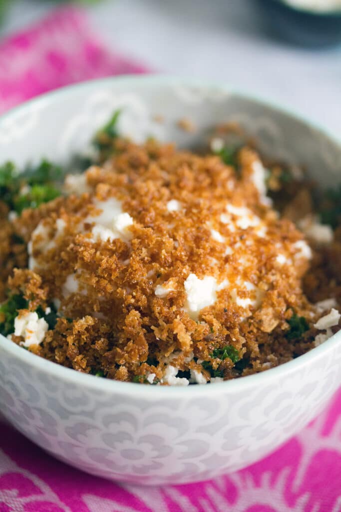Head-on closeup view of Mei Mei's kale salad topped with slow poached fried egg and crispy panko