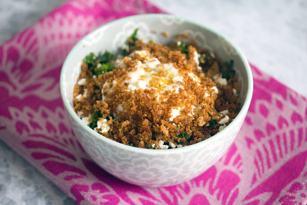 Landscape head-on view of Mei Mei's Magical kale salad with slow poached fried egg and crispy panko