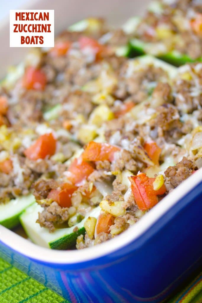 Sideways view of Mexican zucchini boats with turkey and tomatoes in a blue casserole dish with recipe title at the top of the image