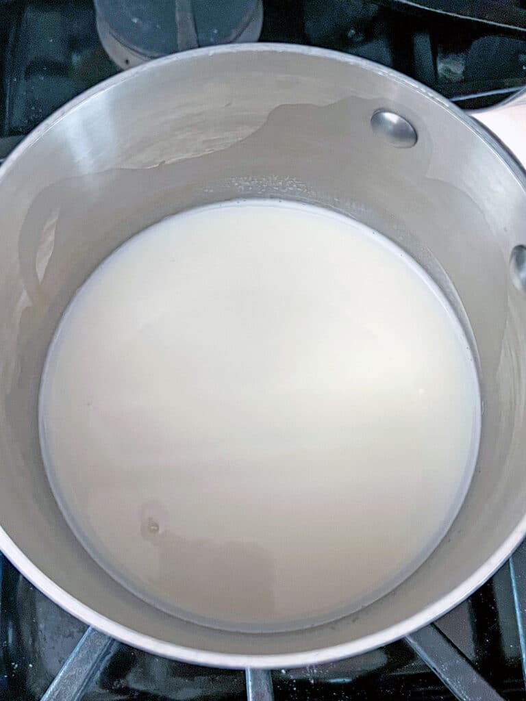Milk and sugar in saucepan.