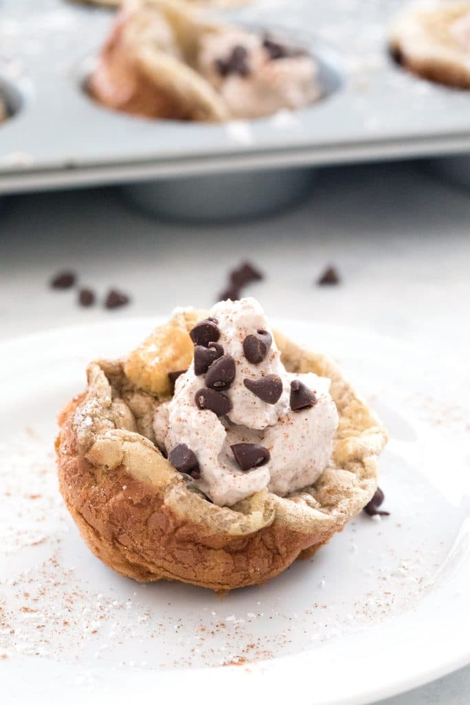 Mini Cinnamon Chocolate Chip German Pancakes with Cinnamon Whipped Cream -- bite-sized brunch made in a muffin tin! | wearenotmartha.com