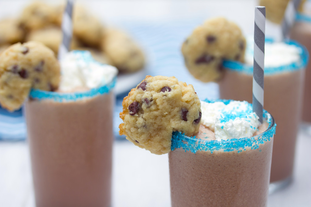 Landscape view featuring closeup of a mini cookie milkshake with cookie garnish with more milkshakes in the background