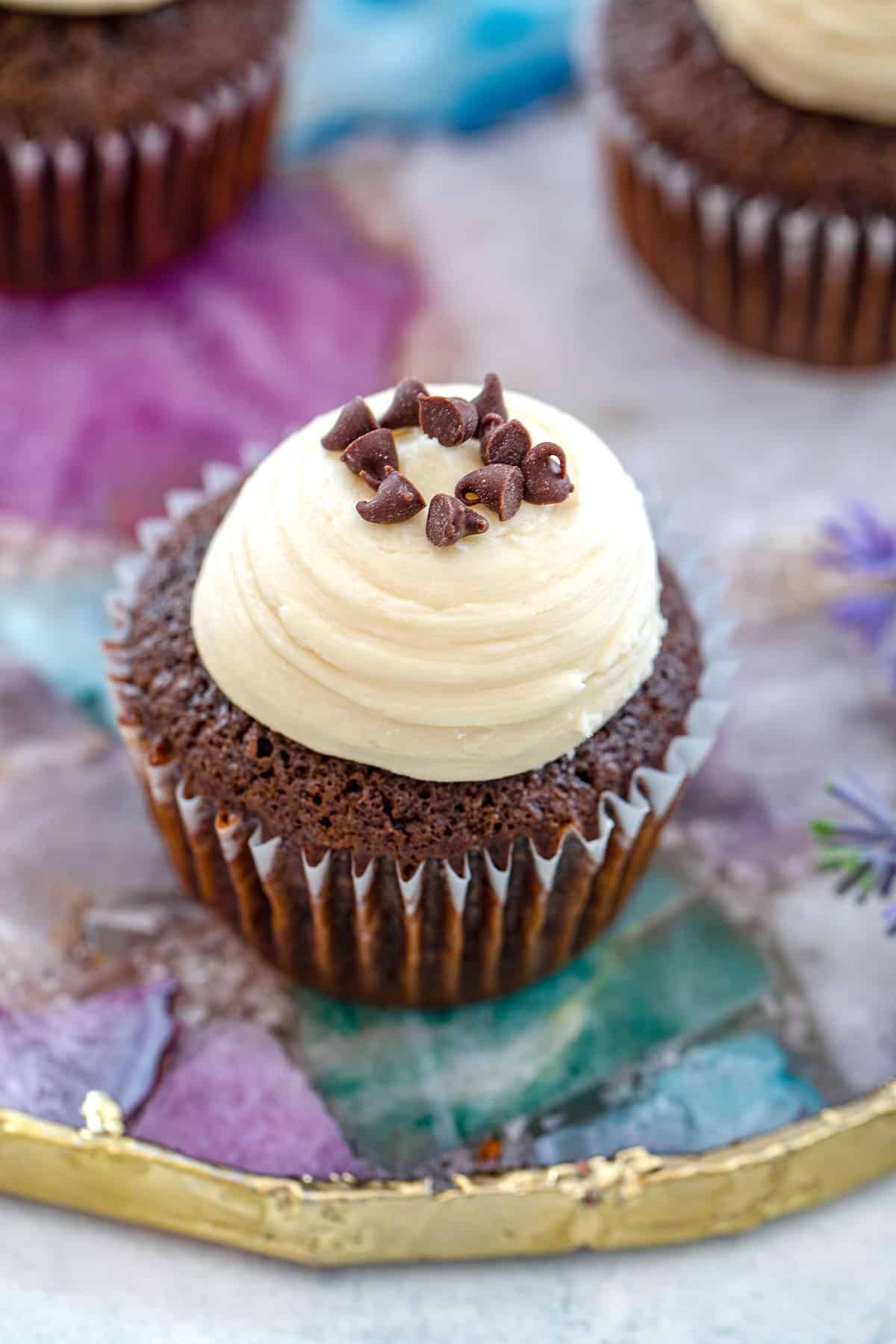 Overhead view of a mint chocolate cupcake topped with Baileys frosting and chocolate chips.