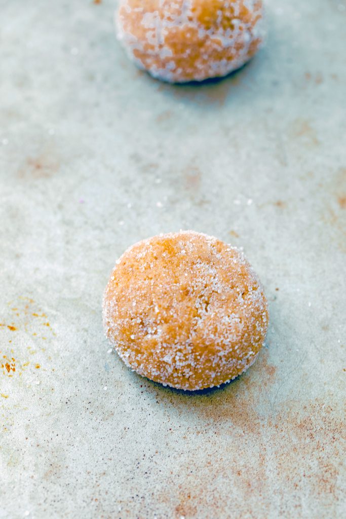 Overhead view of cookie dough formed into balls on baking sheet.
