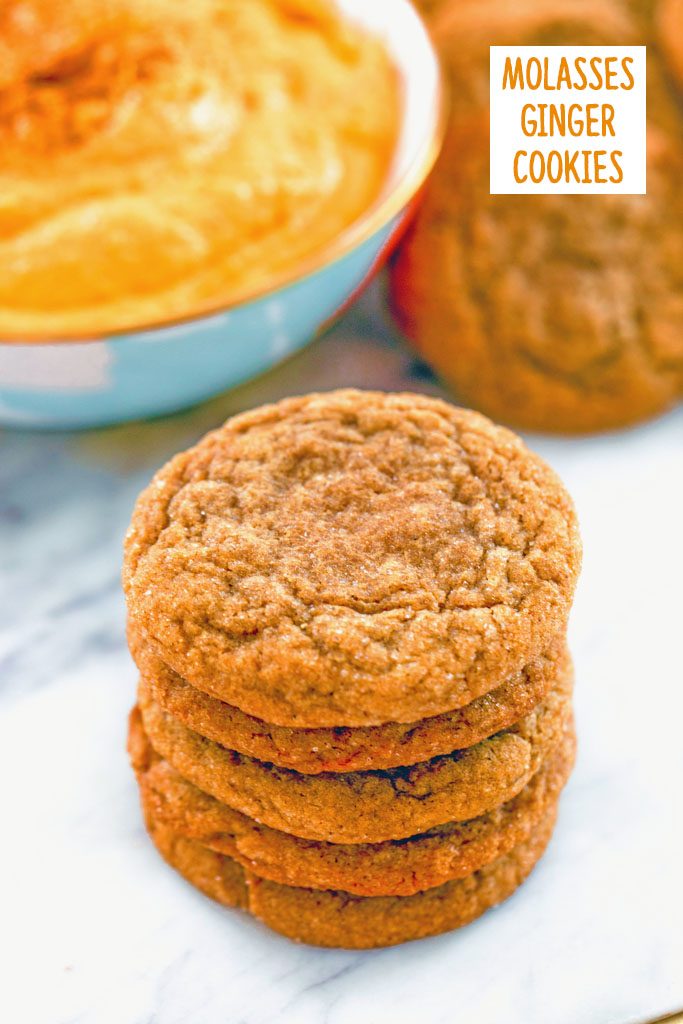Head-on view of a stack of molasses ginger cookies on a marble surface with bowl of sweet pumpkin dip and more cookies in the background and recipe title at top