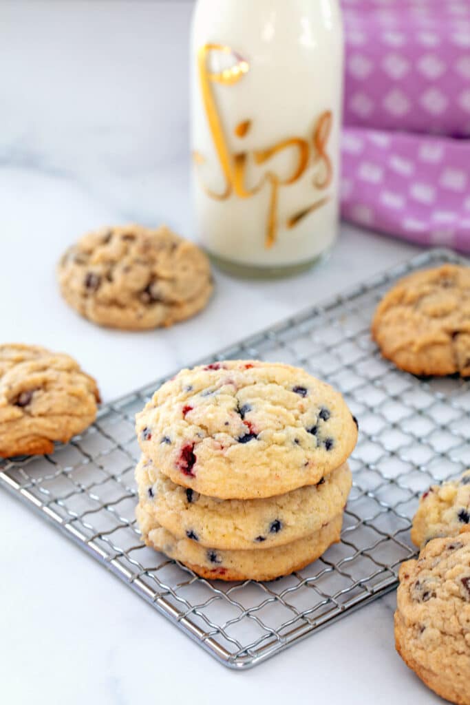 Berry and chocolate chip muffin mix cookies with clear glass of milk in background.