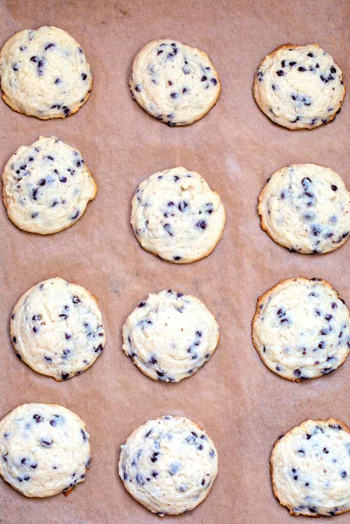 Chocolate chip cookies baked on parchment paper lined baking sheet.