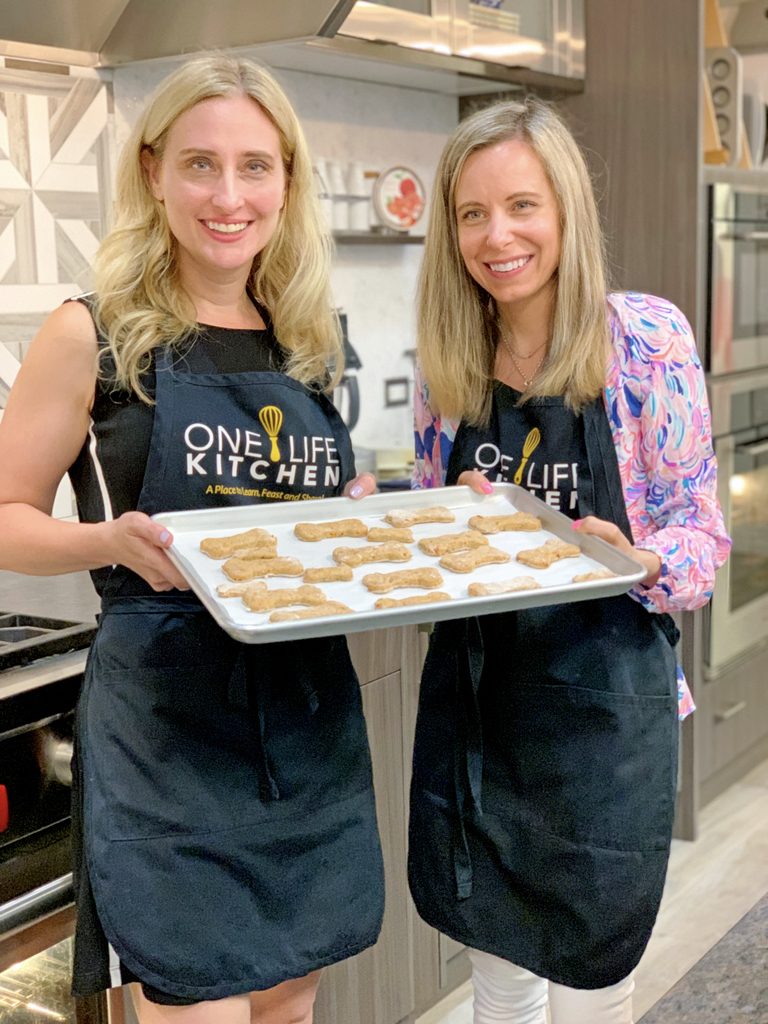 Lauren and Sues holding a tray of chicken dog treats at Barrington's One Life Kitchen