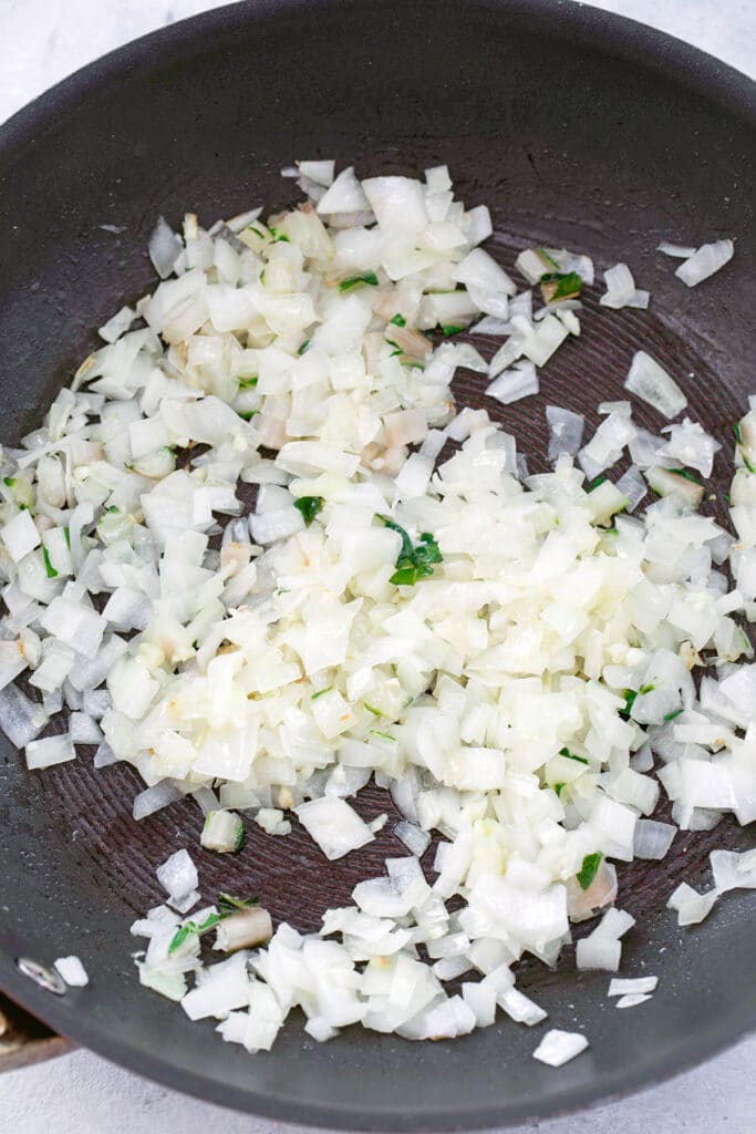Onions, garlic, and chard stems cooking in skillet